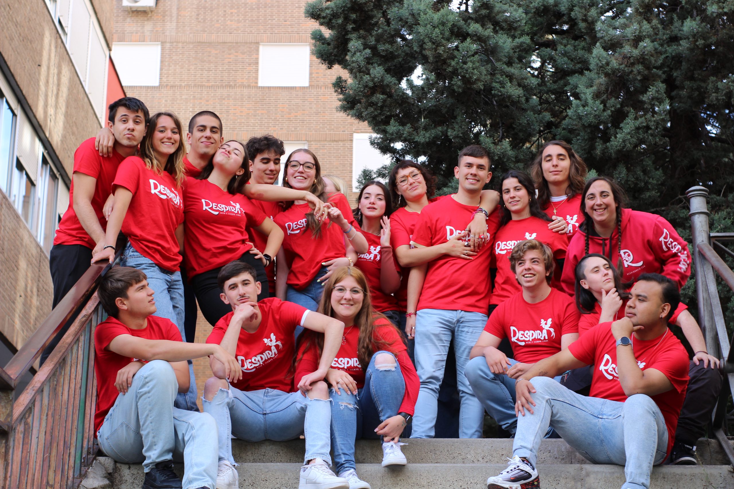 grupo de monitores con camiseta roja sentados en escaleras