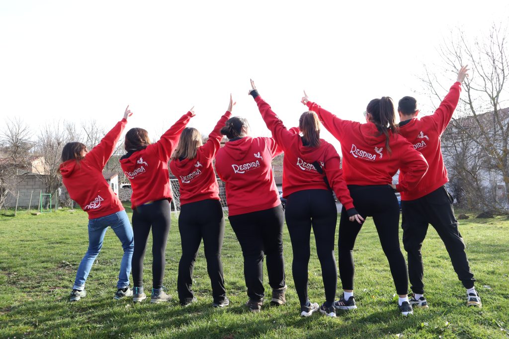 monitores de espaldas con sudadera roja en campo abierto