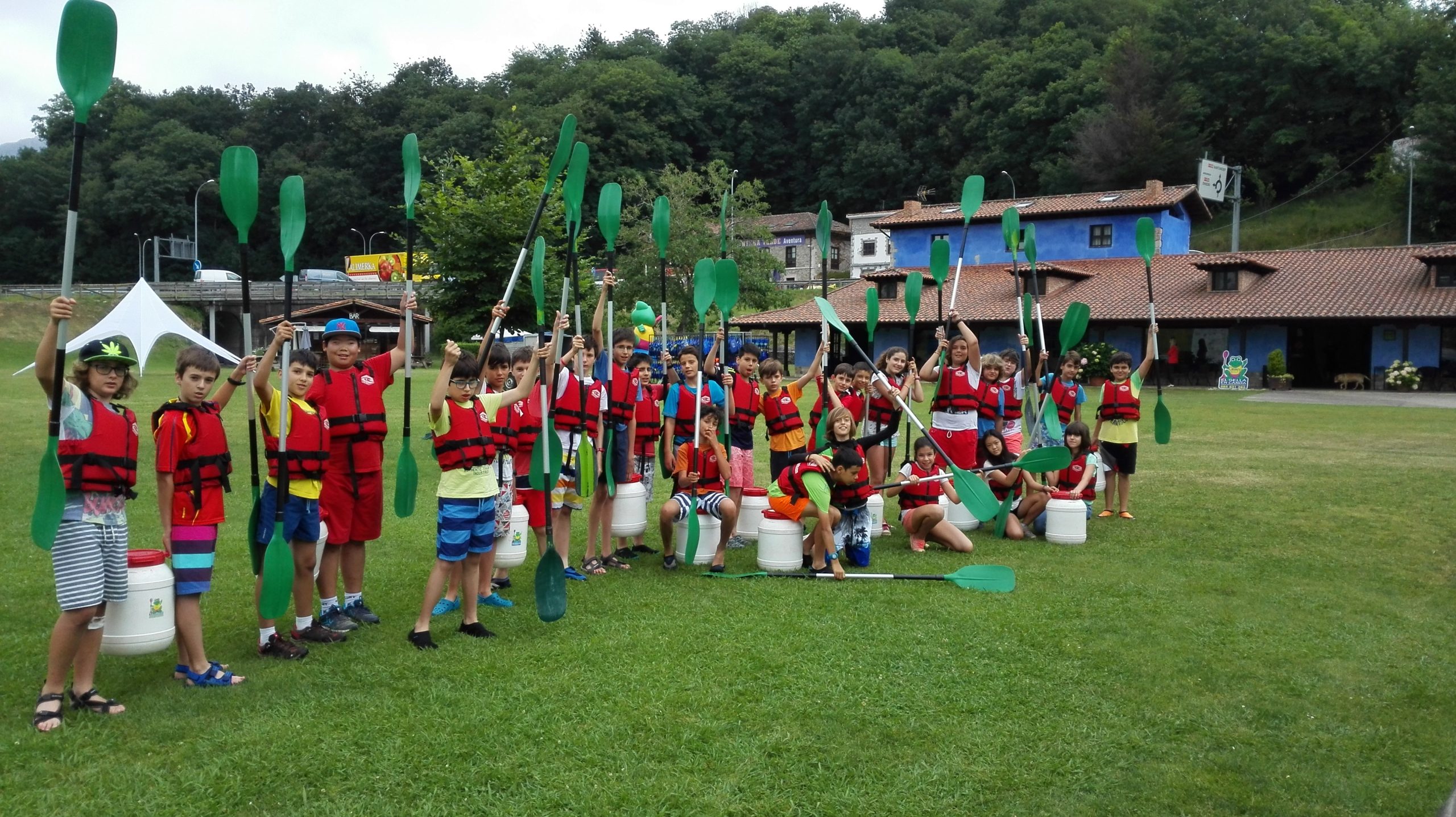 niños con chalecos y remos preparados para actividad acuática