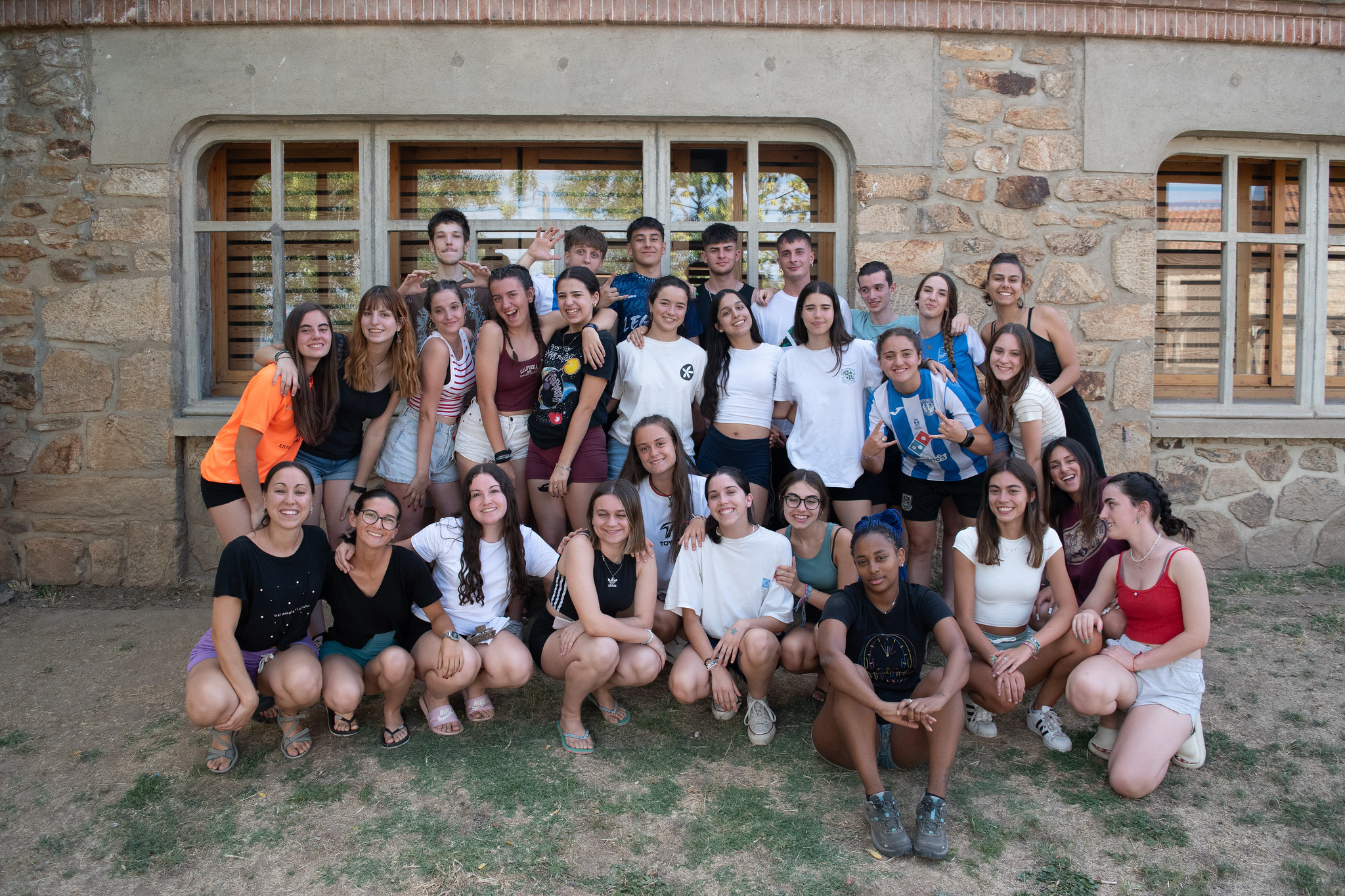 grupo numeroso de jóvenes posando frente a albergue