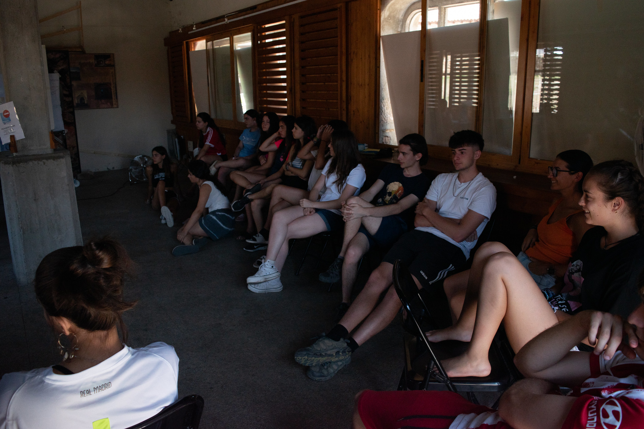 grupo de jóvenes sentados en una charla de campamento
