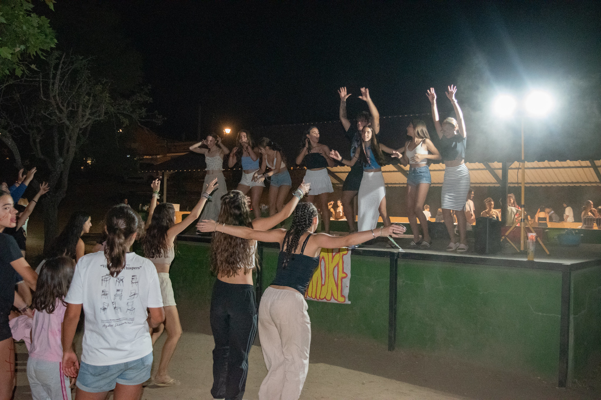 niños y monitores bailando en actividad nocturna de campamento