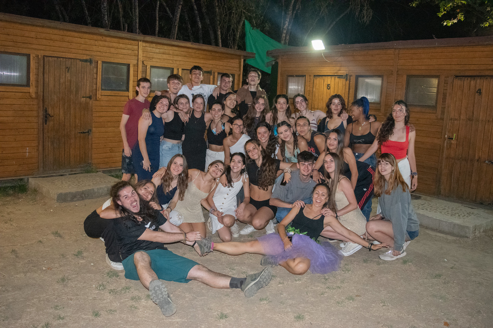 gran grupo de jóvenes posando de noche en campamento