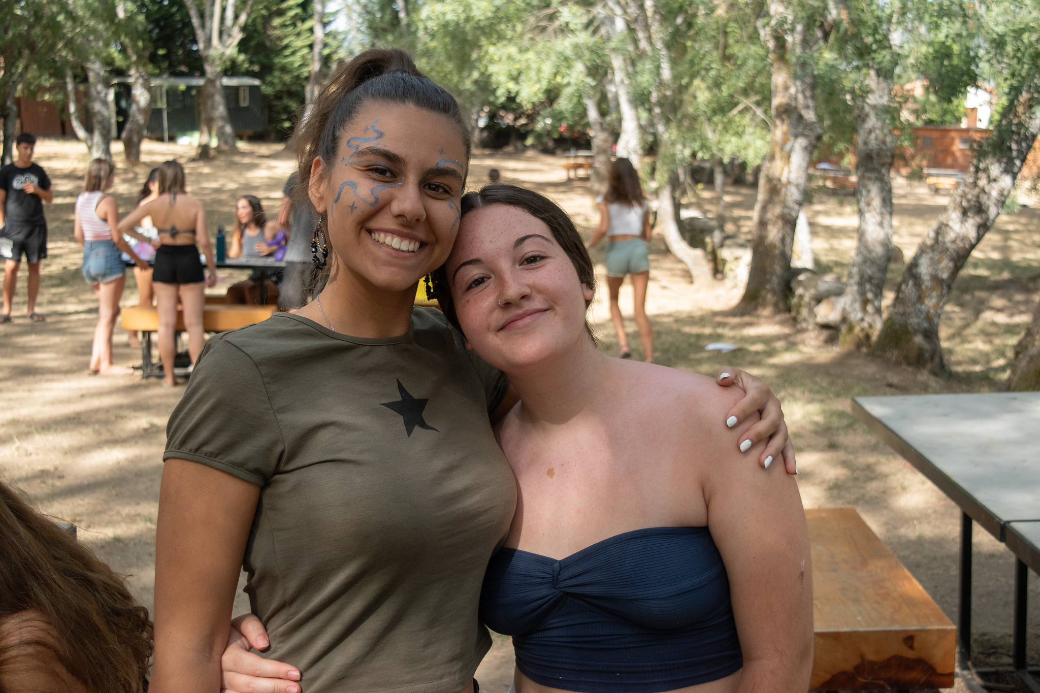 dos chicas abrazadas sonriendo en el campamento