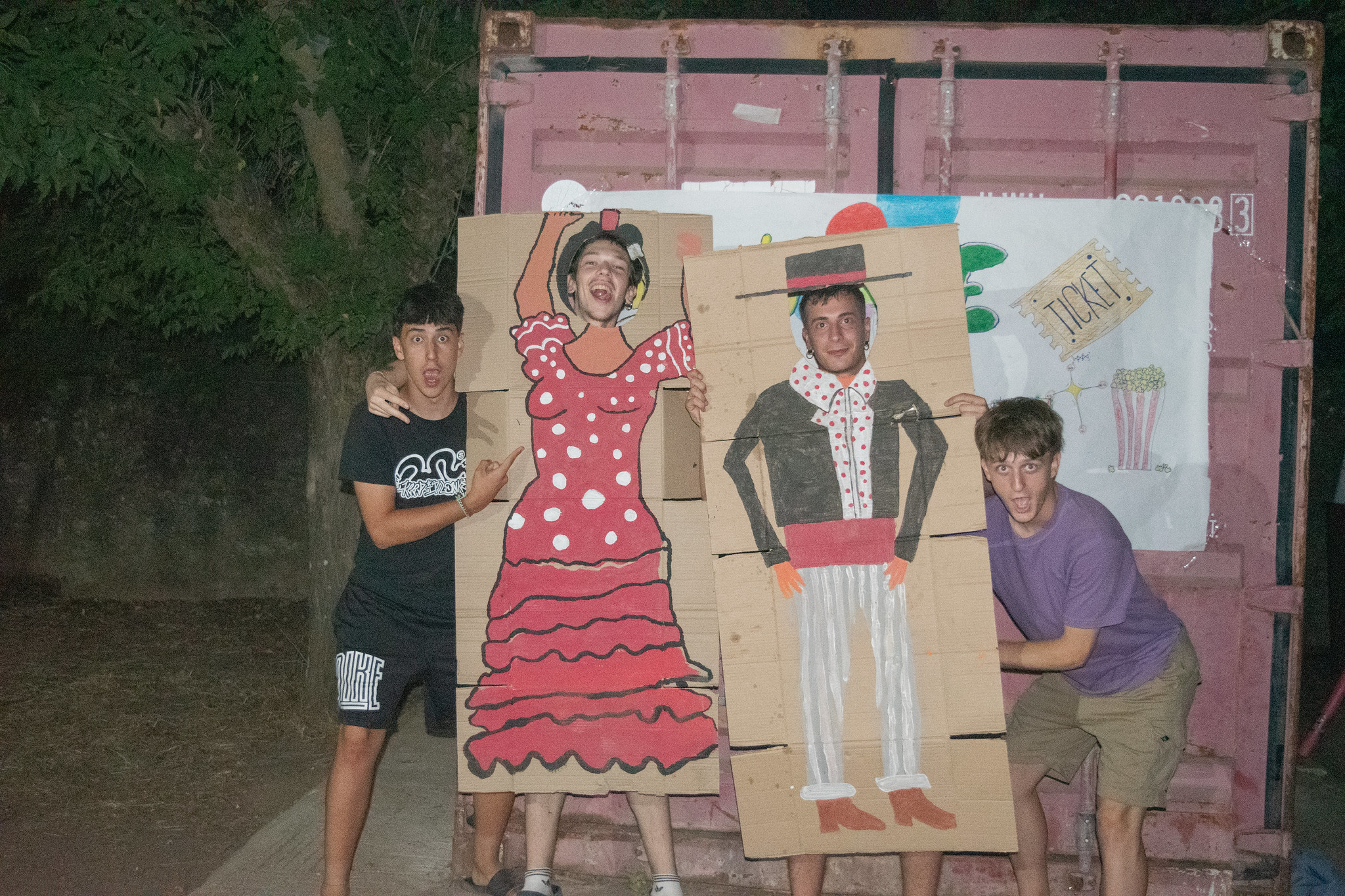 jóvenes posando con cartón de trajes flamencos