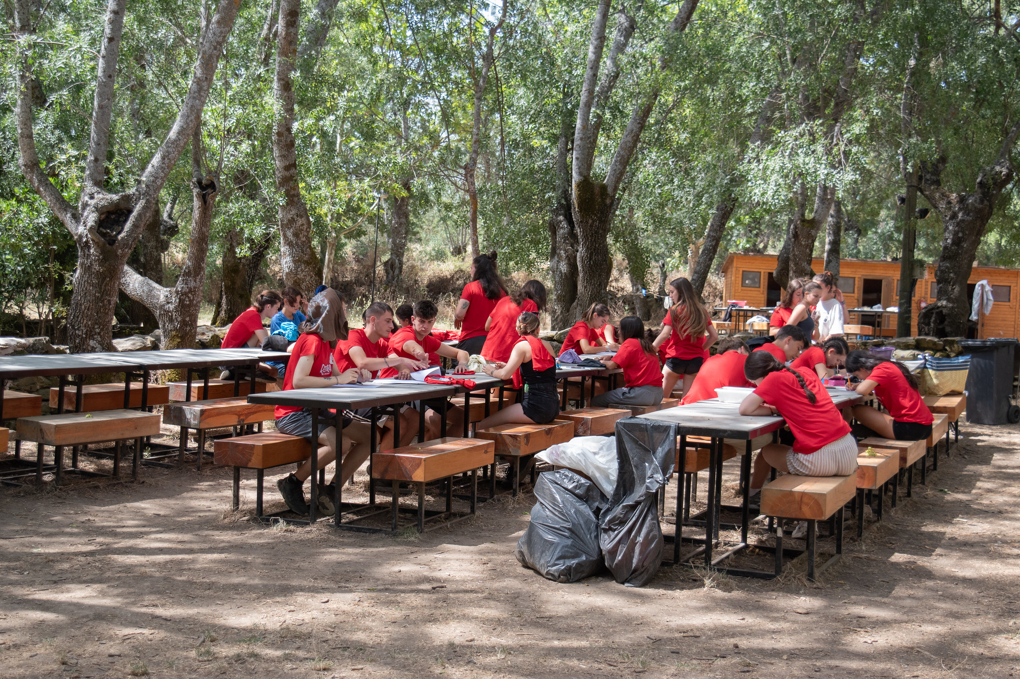 grupo de jóvenes con camisetas rojas sentados al aire libre