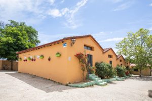 fachada exterior de albergue rural con macetas coloridas