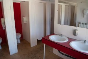 baños con lavabos y cabinas en albergue
