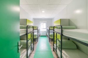 dormitorio con literas verdes en albergue juvenil
