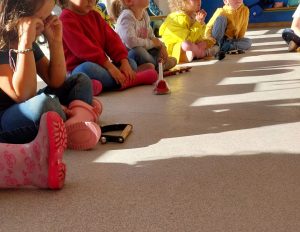 grupo de niños pequeños sentados en el suelo al aire libre