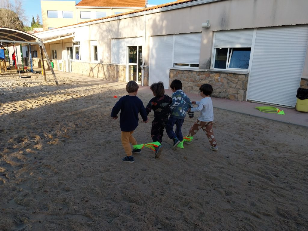 niños corriendo juntos en patio de arena exterior