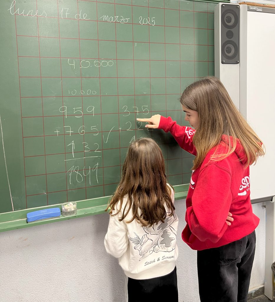 dos niñas resolviendo operaciones matemáticas en pizarra