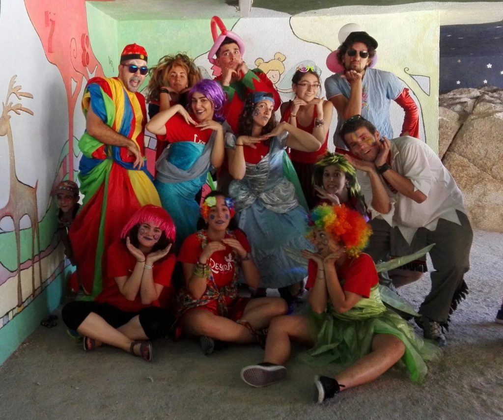 grupo de monitores con disfraces coloridos en campamento