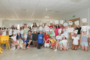 grupo de niños con gorros de cocinero en taller de cocina