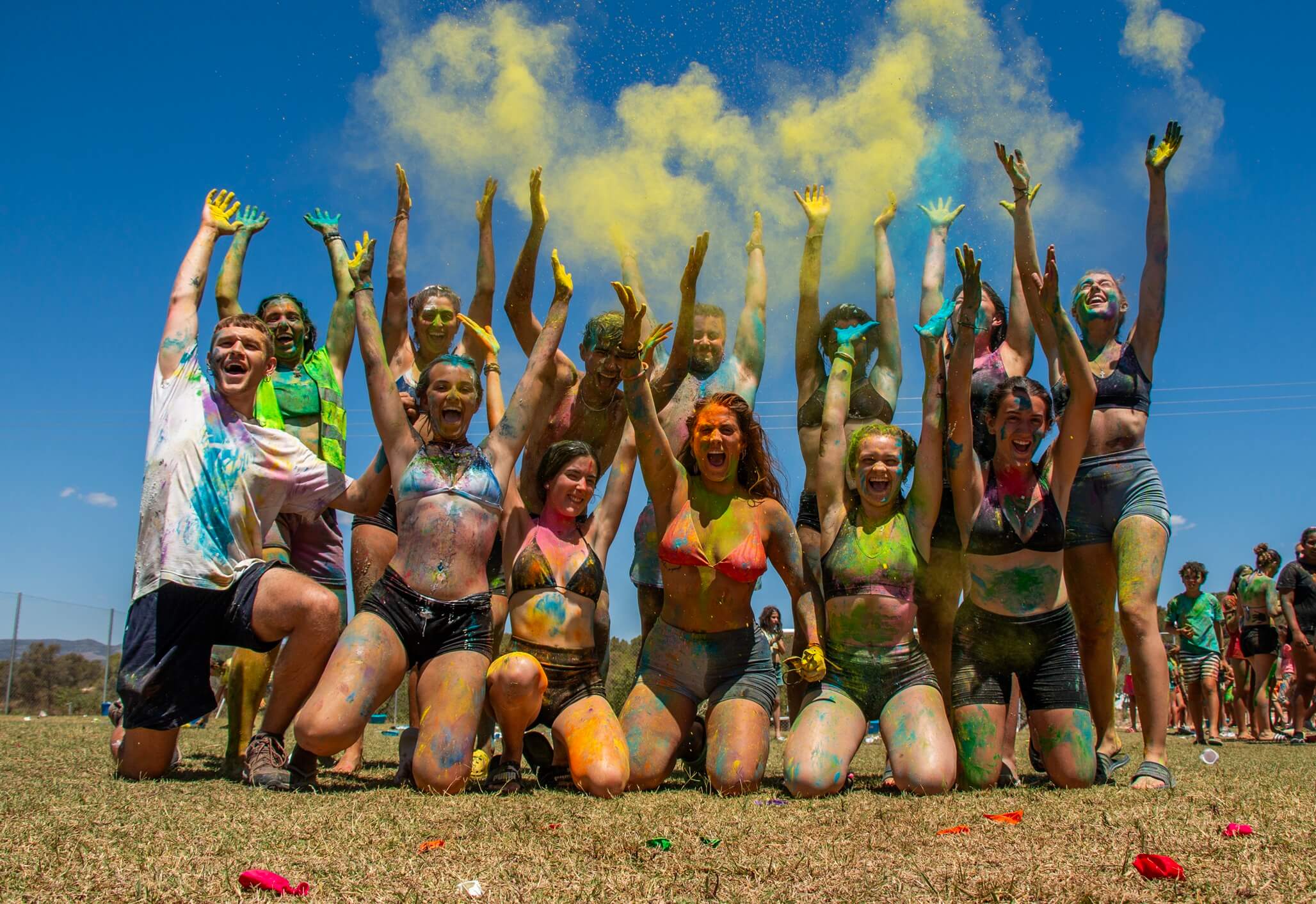 grupo de jóvenes lanzando polvos de colores holi al aire
