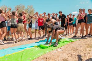 grupo de jóvenes jugando con tobogán de agua al aire libre